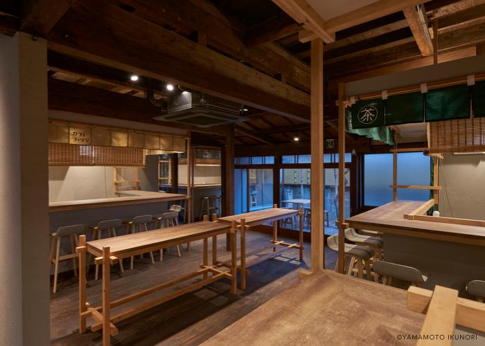  Intérieur du café Mikan Club dans le jardin d'Urasando, avec des tables et des chaises en bois rustiques 